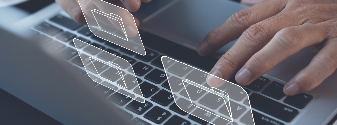 Hände tippen auf eine Computertastatur, darüber sind transparente, digitale Ordnersymbole eingeblendet.
